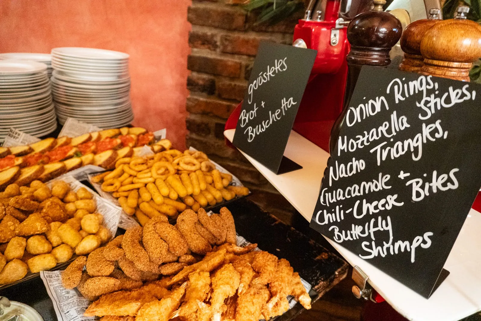 Gast nimmt sich Pommes und Chicken vom Buffet
